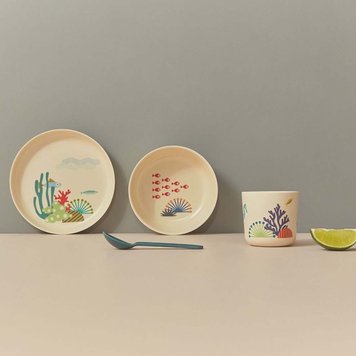Set of children's dishes with underwater-themed designs on a white background