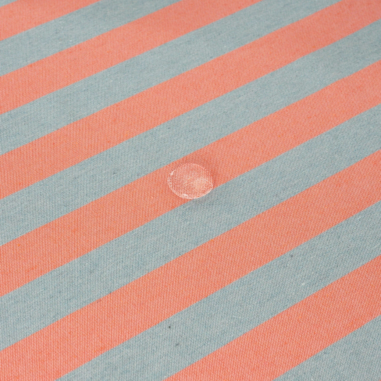 Chair with striped cushion next to a table with a striped tablecloth.