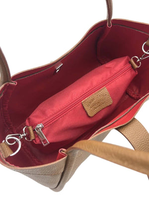 Tan handbag with redinterior and handles on a white background