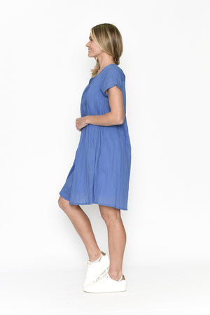 Woman wearing a blue dress standing against a white background