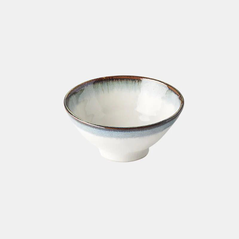 White ceramic bowl with a blue rim on a light gray background