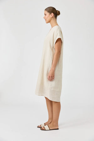 Woman wearing a beige dress on a white background