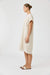 Woman wearing a beige dress on a white background