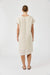 Person wearing a beige dress on a white background