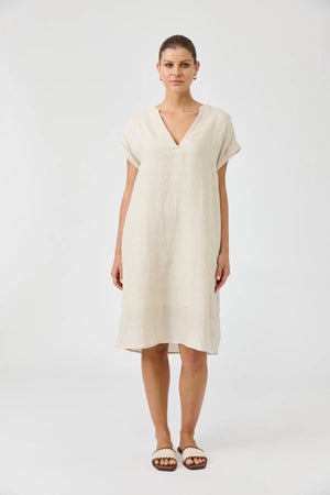 Woman wearing a beige dress on a white background