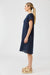 Woman wearing a navy blue dress on a white background
