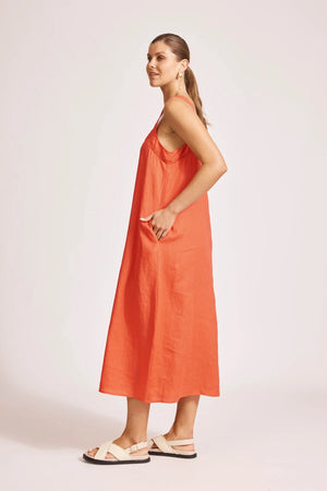 Woman wearing an orange dress on a plain background