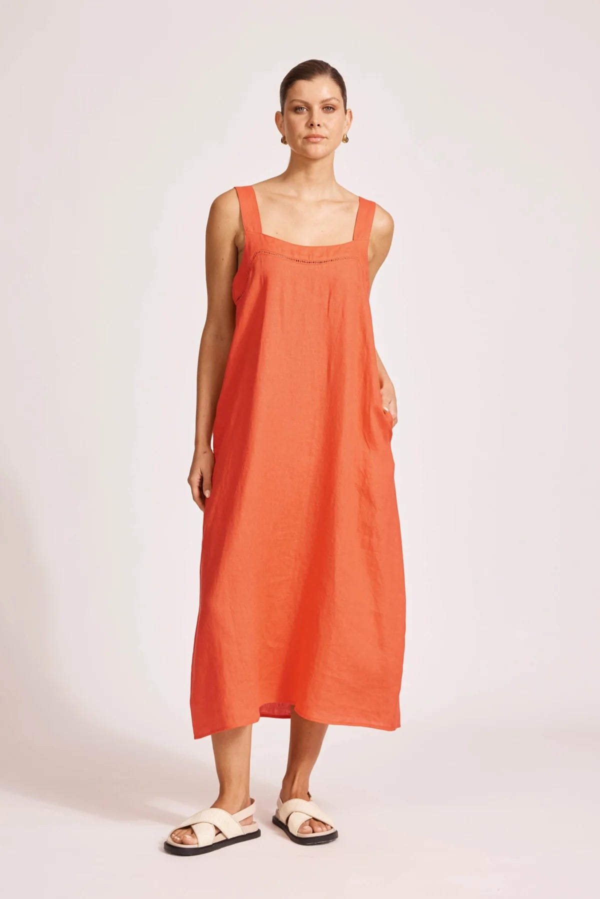 Woman wearing an orange dress against a white background