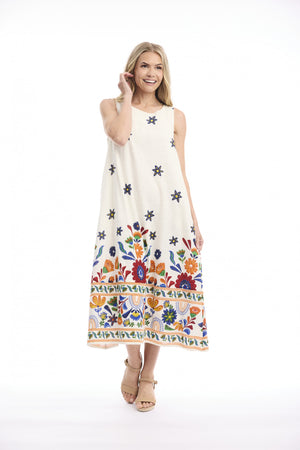 A woman modeling a sleeveless cream maxi dress with colorful floral embroidery and star motifs, set against a plain white studio background.