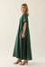 Woman wearing a green dress against a plain background