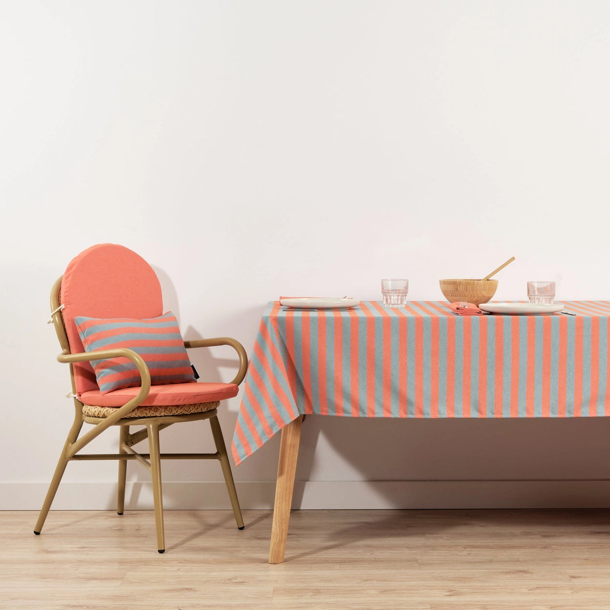 Chair with striped cushion next to a table with a striped tablecloth.