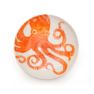 Round ceramic plate with an orange octopus design on a white background