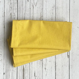 Yellow fabric napkins on a wooden surface