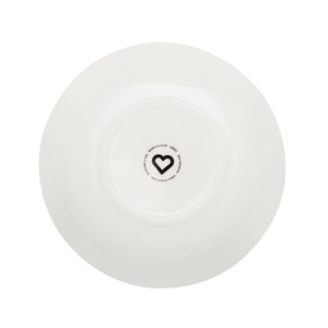 A white ceramic plate shown from a top-down view, featuring a small black heart logo and circular text printed in the center.