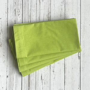 Stack of green napkins on a white wooden surface