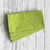 Stack of green napkins on a white wooden surface
