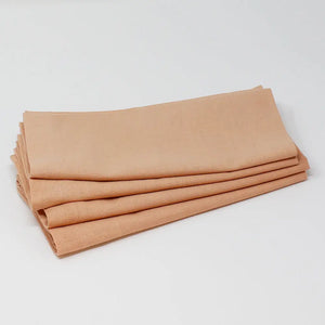Stack of folded nude napkins on a white background