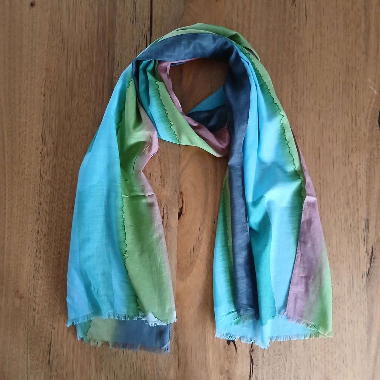 Colorful scarf draped over a wooden surface