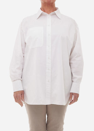 Person wearing a white button-up shirt and beige pants on a white background