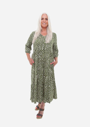Woman wearing a green patterned dress on a white background
