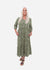 Woman wearing a green patterned dress on a white background