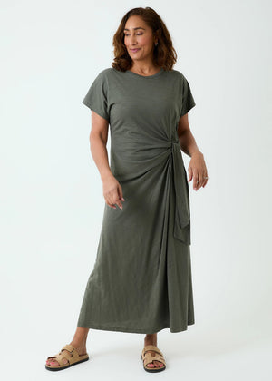 Woman wearing a green dress with a knot detail on a white background