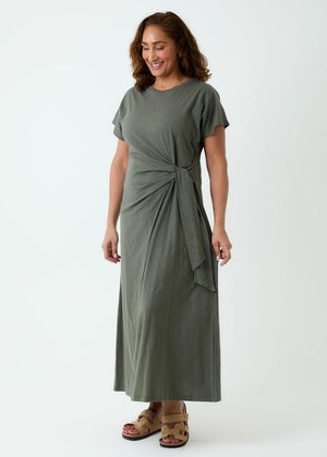 Woman wearing a green dress with a knot detail on a white background