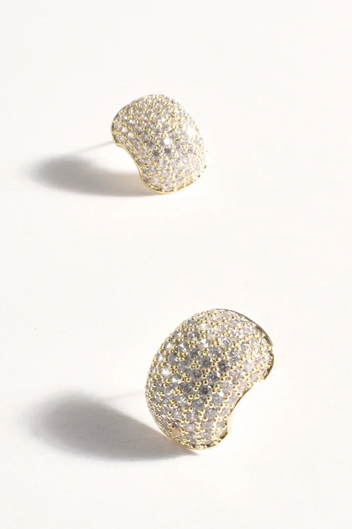 Pair of gold glittery earrings on a light gray background