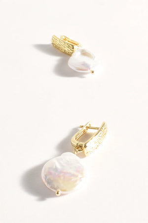 Gold earrings with pearl-like stones on a white background