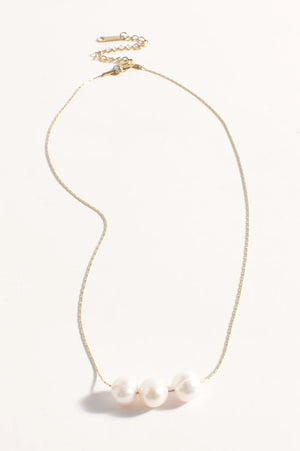 Gold necklace with three pearls on a white background
