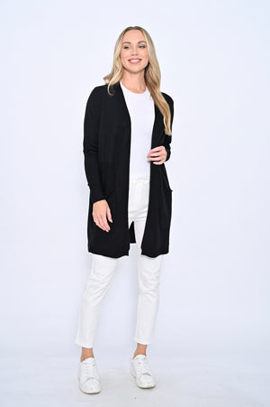Woman wearing a black cardigan, white shirt, and pants on a white background
