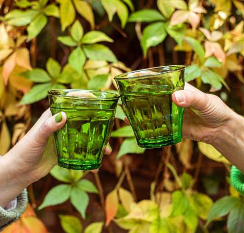 Green glass tumbler on a white background