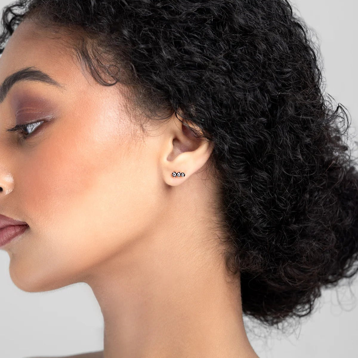 Gold earrings with clear gemstones on a white background