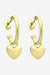 Gold hoop earrings with heart pendants on a white background
