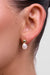 Close-up of an ear wearing a pearl earring with gold top.