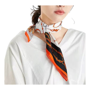 A woman wearing a white blouse and a patterned silk neck scarf tied around her neck. The scarf features a black and orange chain-link design with orange and gray accents on a white background.