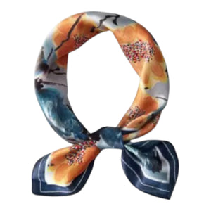 A square silk scarf with a watercolor-style floral print in orange, blue, and gray, tied in a loop with a bow at the bottom, shown on a plain white background.