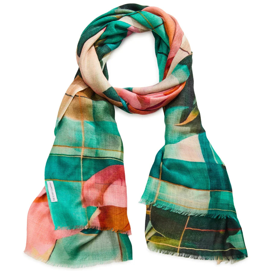 Woman holding a colorful floral scarf against a neutral background