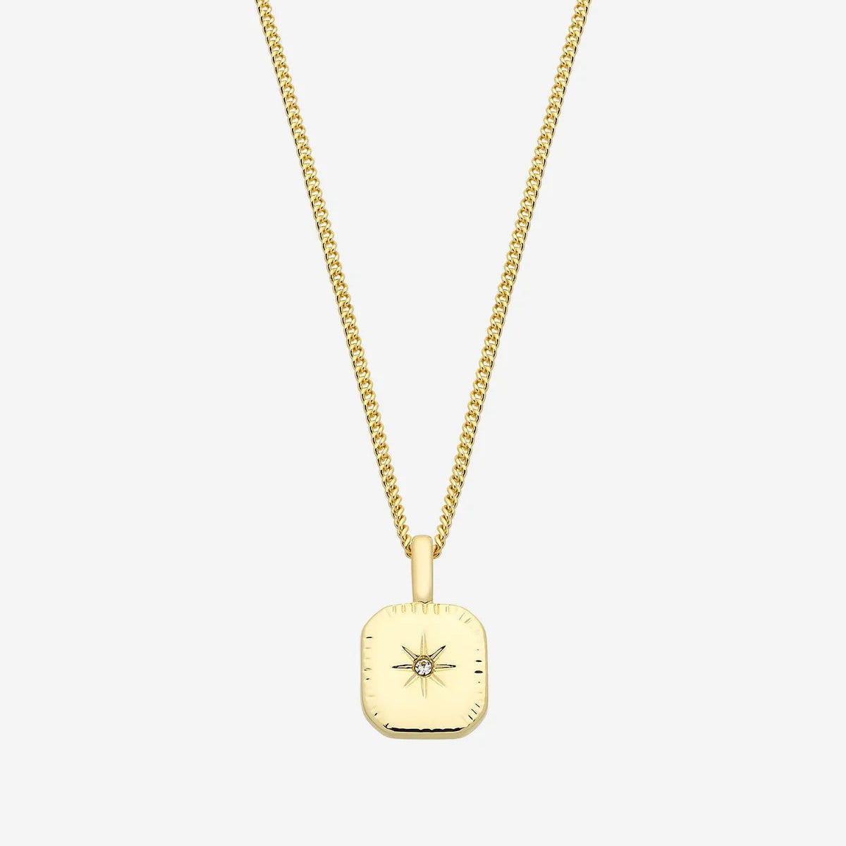 Gold necklace with a pendant on a person's neck against a neutral background