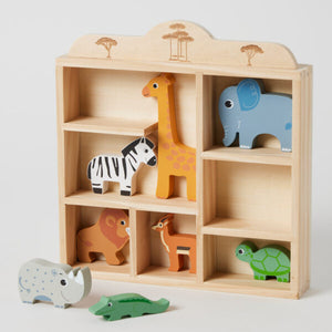 Wooden toy shelf with animal figurines on a light gray background