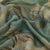 Close-up of patterned fabric with green, brown, and beige colors.