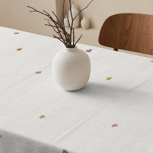 White vase with branches on a tablecloth