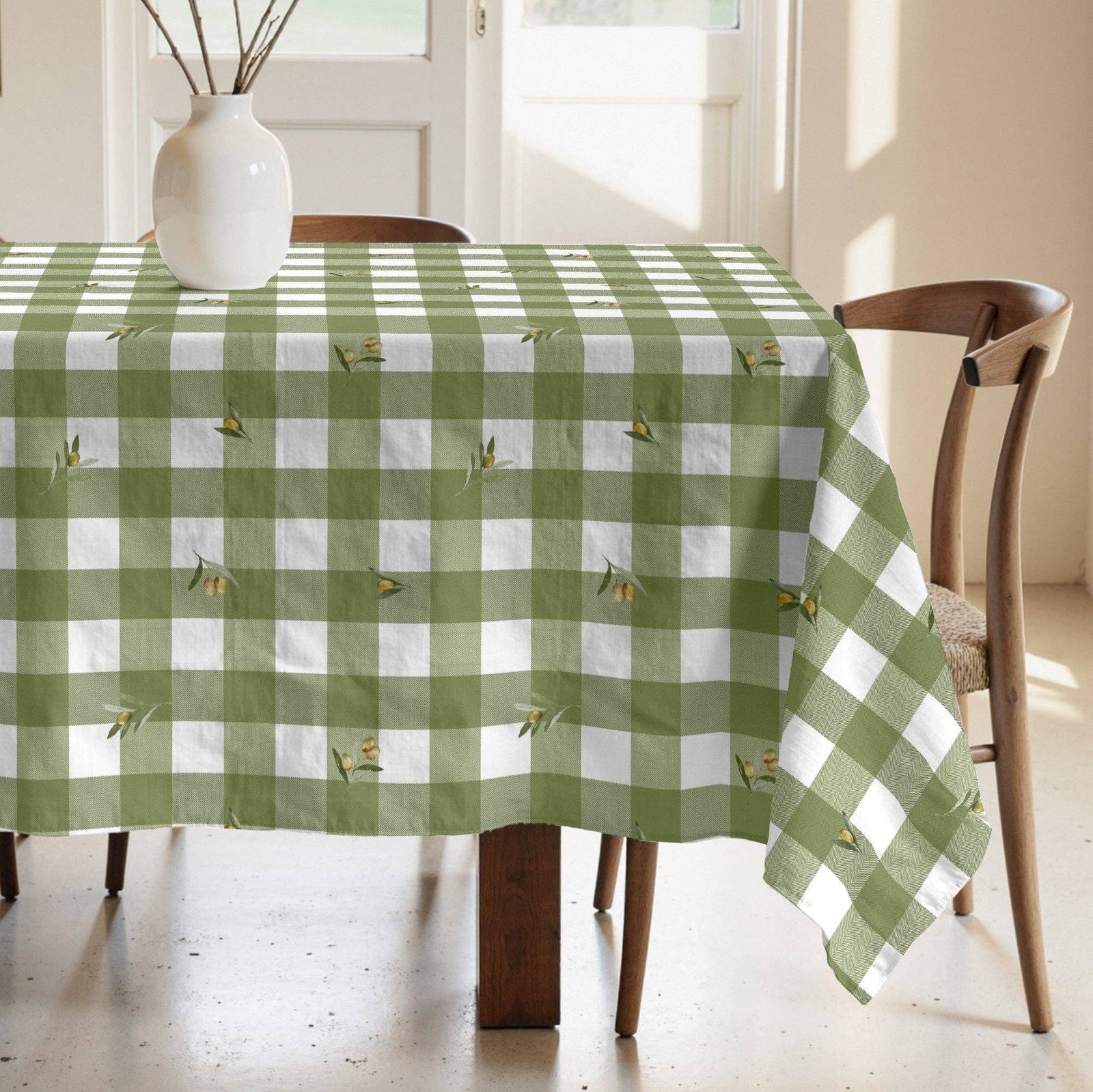 Green and white checkered tablecloth on a wooden table with chairs in a bright room.