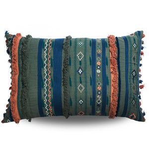 Decorative pillow with tribal patterns and fringes on a white background
