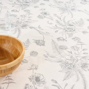 Floral patterned tablecloth with a wooden bowl on a white background