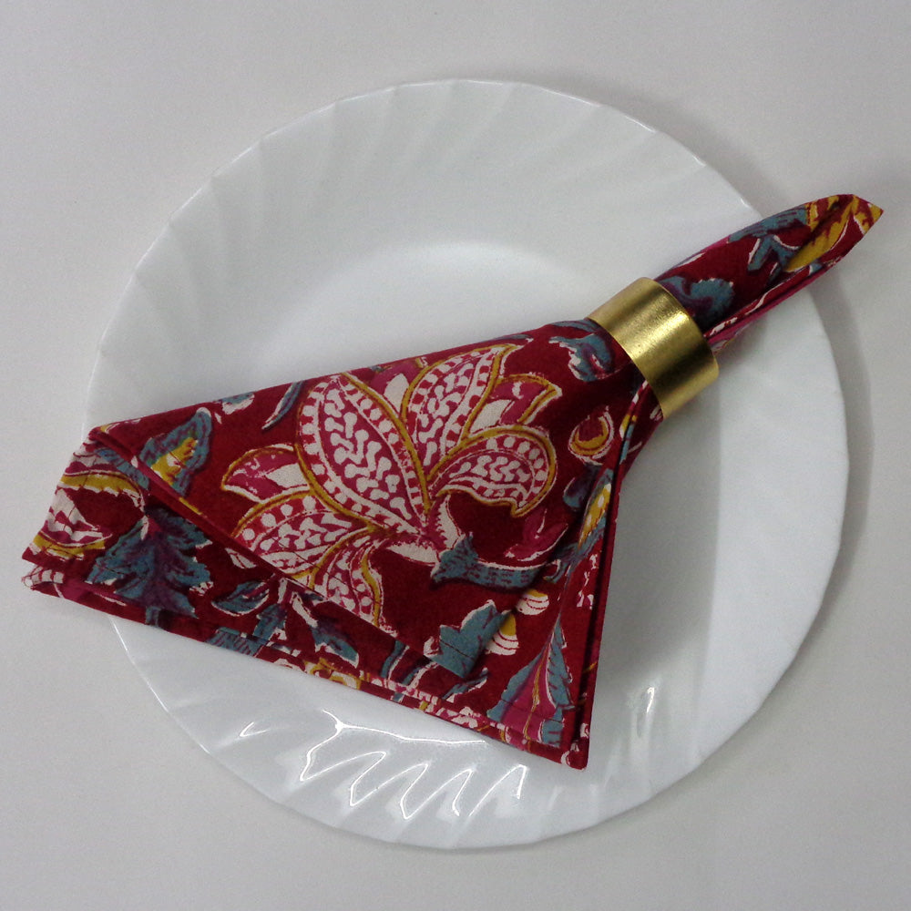 Set of four red floral patterned napkins on a white background