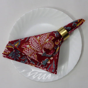 Decorative red paisley napkin with gold accent on a white plate