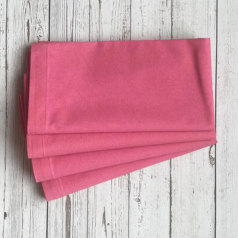 Stack of pink napkins on a wooden surface