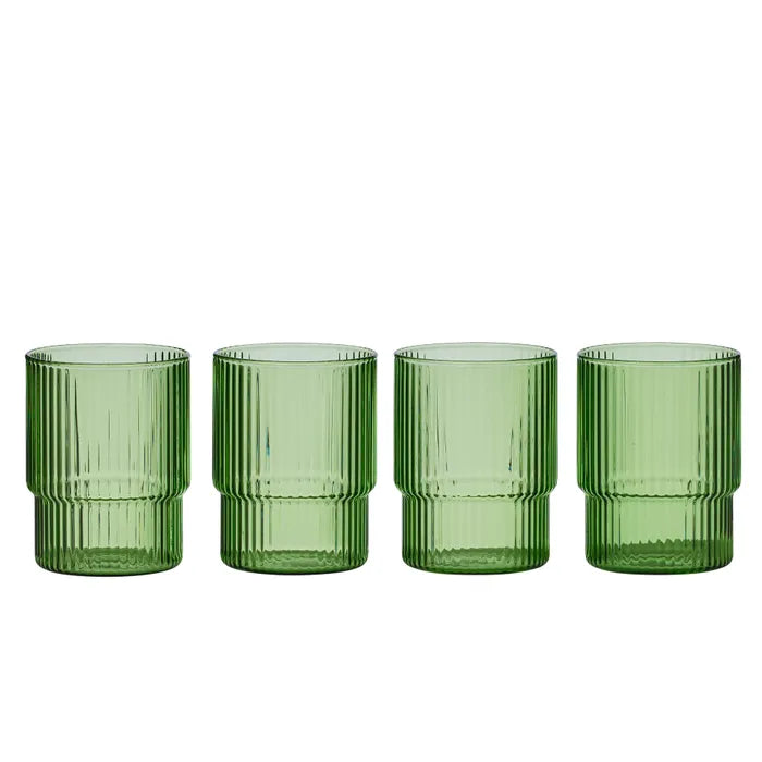 Set of four green ribbed glass tumblers on a white background