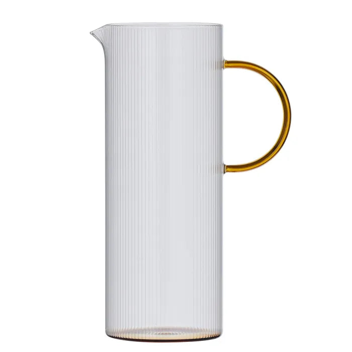 Clear ribbed glass pitcher with an amber handle on a white background